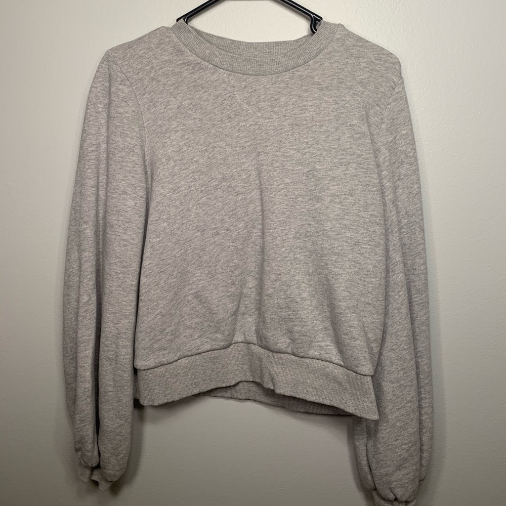 Grey sweatshirt with ruffled cuffs.